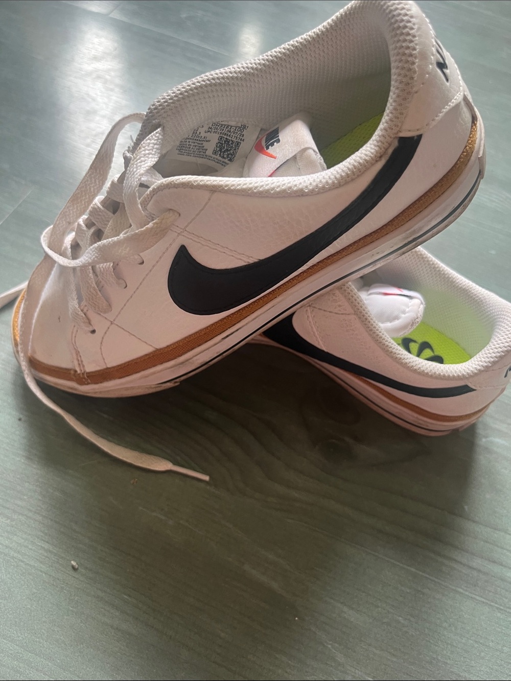 Nike White Sneakers with Black Swoosh and Gold Trim